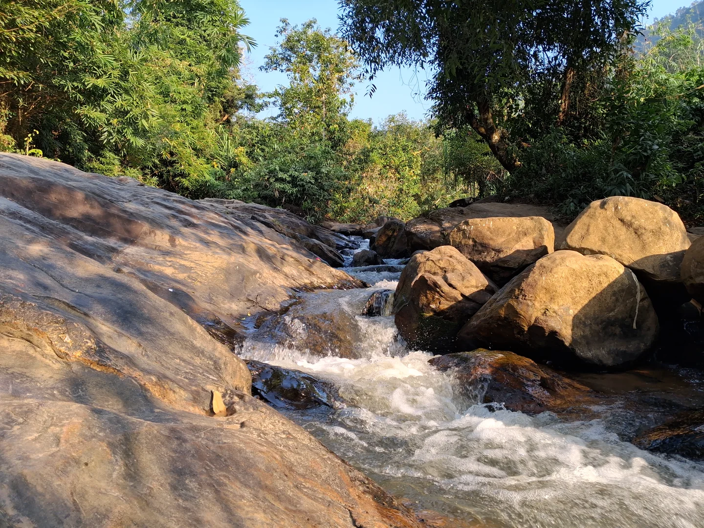 The Kopili River cascading over stones, offering a serene and picturesque view