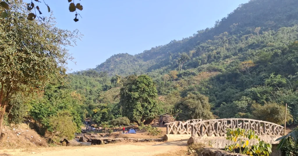 Wide angle view of the main spot with the iconic bridge on Kopili river Wide-angle view of Kopili Picnic Spot featuring the iconic bridge and lush greenery