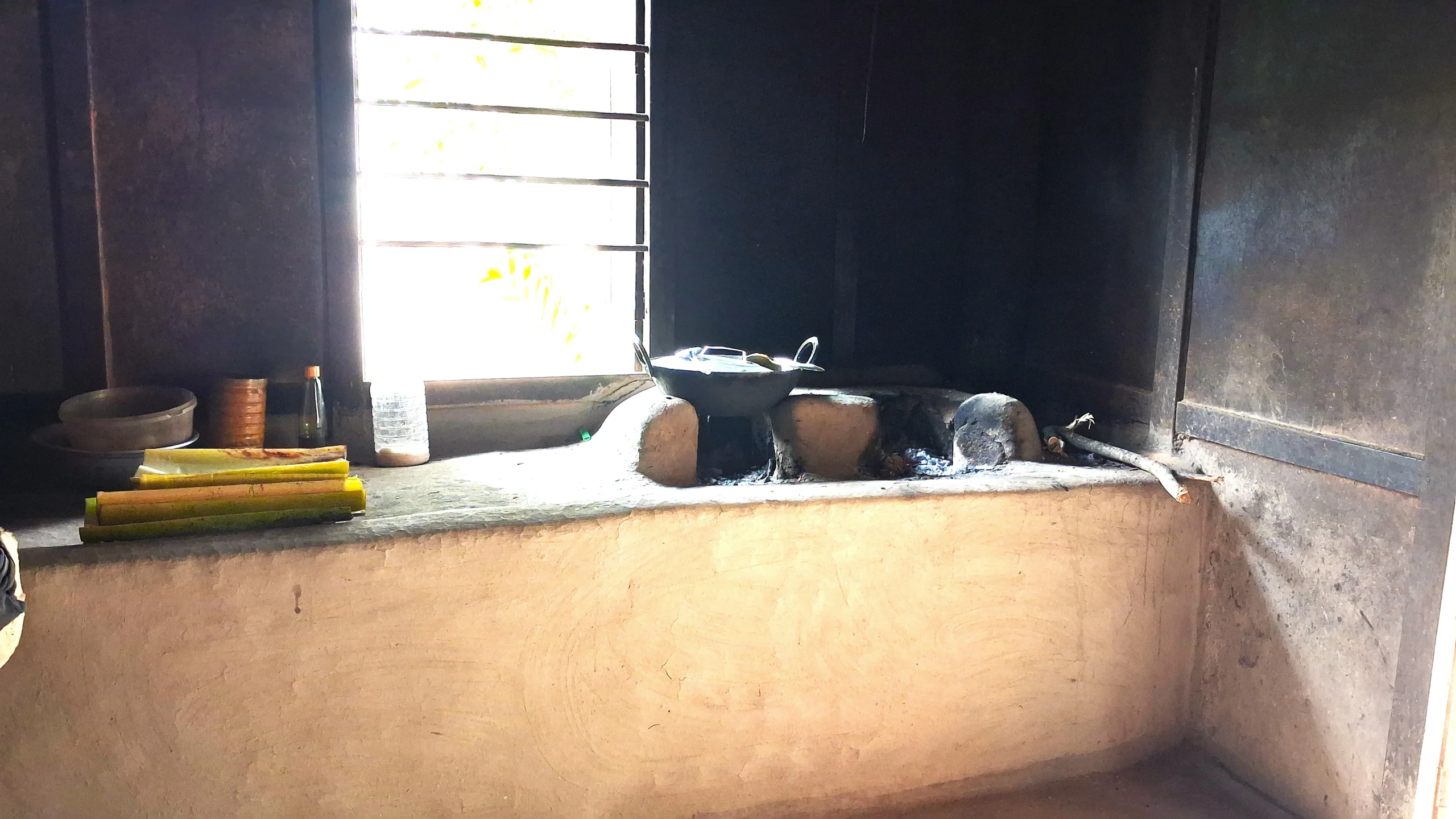 Traditional chulha cooking in an Assamese village kitchen with wood fire at Nasiriba