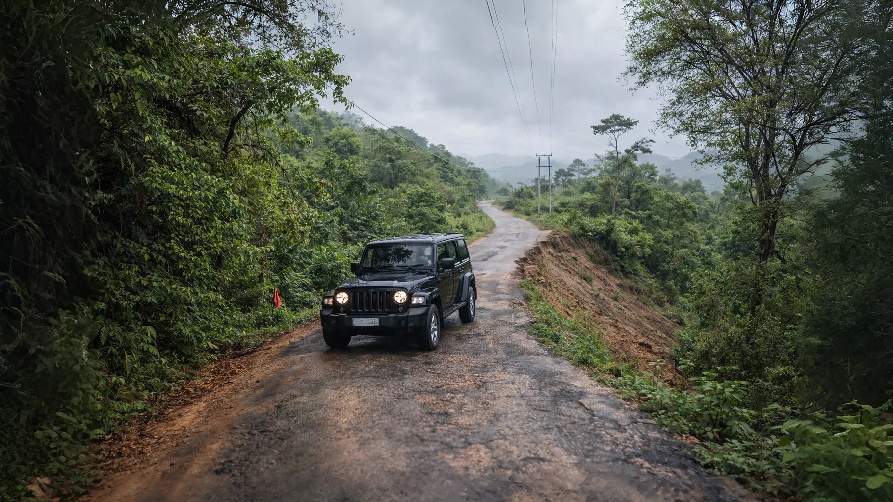 SUV navigating the narrow, winding mountain track to Montang Valley summit