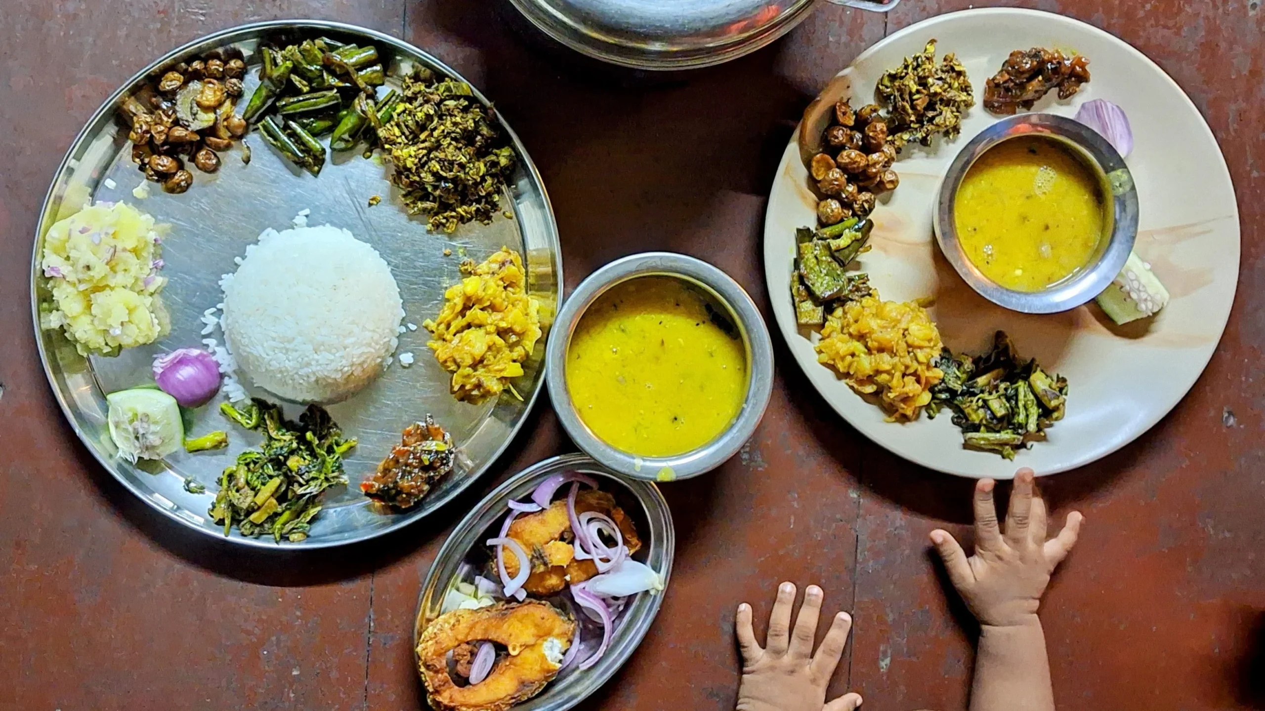 Assamese veg thali at Chandubi Lake View Homestay with multiple vegetable dishes, rice and a separate fish fry