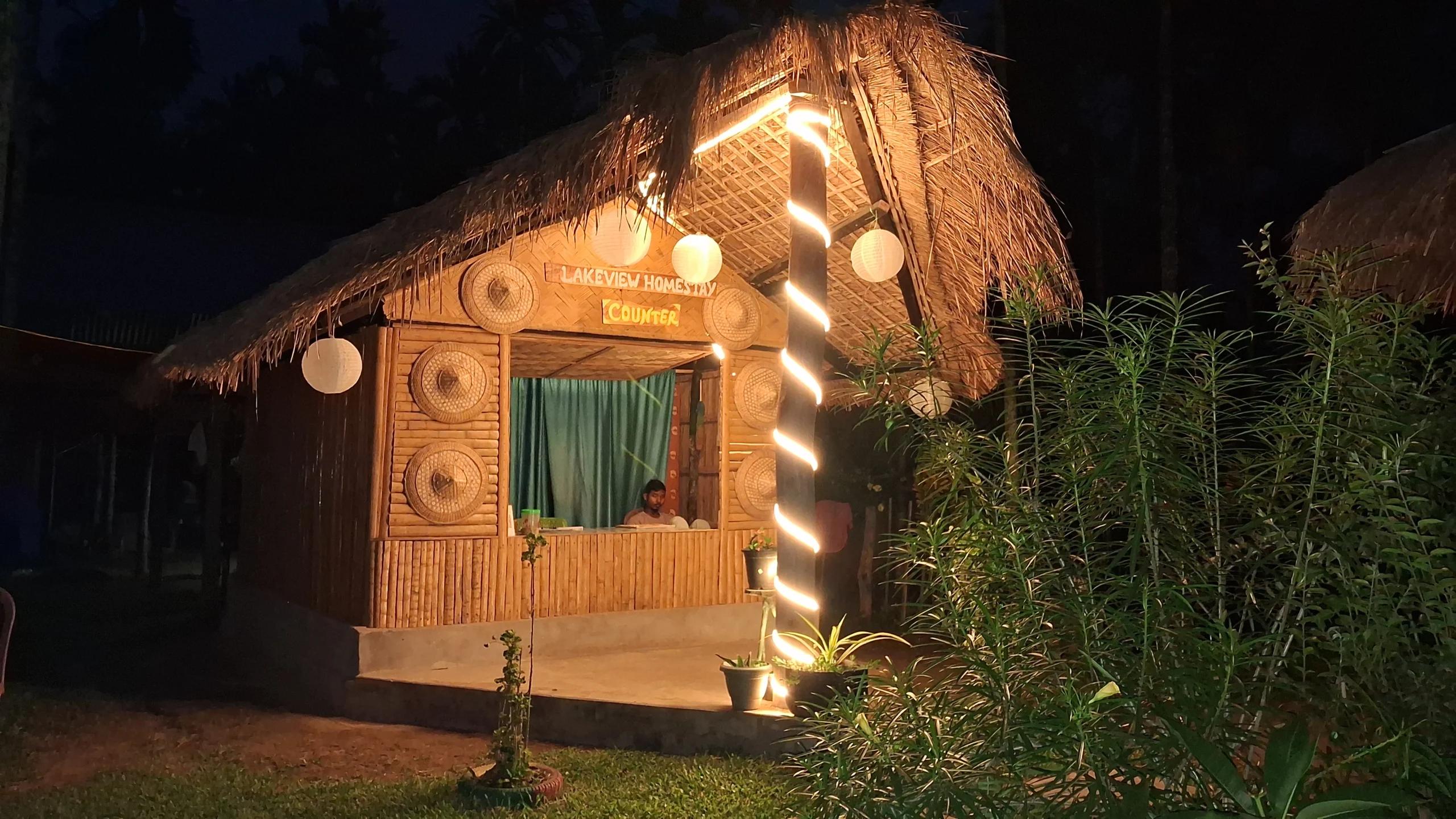 A beautiful leaf-thatched bamboo hut serving as the Reception of Chandubi Lake View Homestay in the night